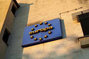 Old rusty sign of the European Union on the facade of the house.