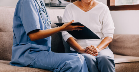 Doctor showing medical card to patient at table in clinic, closeup