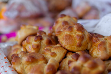 Traditional Day of the Dead puff pastry or Day of the Dead bread on tray for sale in a market in Mexico