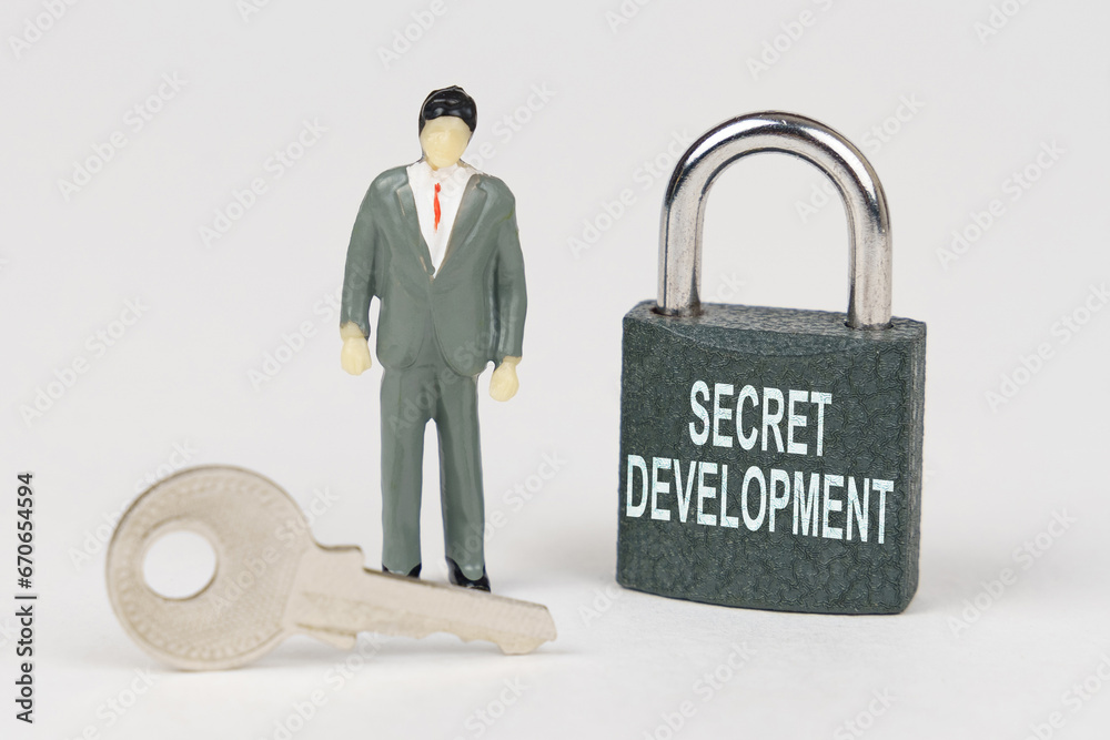 Poster On a white surface there is a figurine of a businessman, a key and a lock with the inscription - Secret development