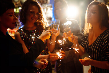 Three young Woman with champagne glasses at night club. Women friends drinking champagne in the bar.