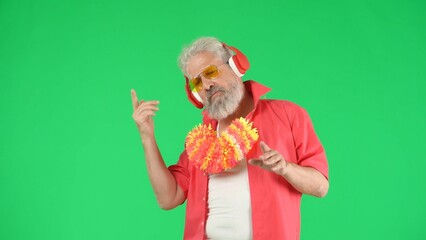 Portrait of senior man hipster on Chroma key green screen background, man in headphones posing...