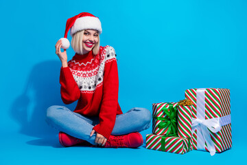 Obraz premium Full length photo of dreamy shiny lady santa helper dressed ornament sweater preparing xmas gifts isolated blue color background