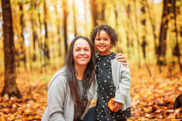 mother and daughter having fun in autumn park