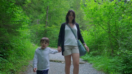 Mother and Son Trekking Together in Forest Trail, Weekend Family Hiking Adventure, walking forward
