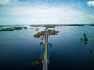 Flooded country roads and flooded meadow. Flight over a flooded country road in a beautiful meadow at sunset. Aerial view.