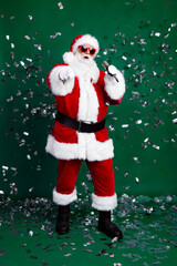 Full length photo of funky cheerful santa dressed red costume pointing finger you singing new year carols isolated green color background