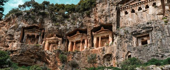 Dalyan Turkey ancient Lycian caved Temple tombs , green trees, amazing nature of Koycegiz, blue sky with white small clouds, popular tourist holiday destination