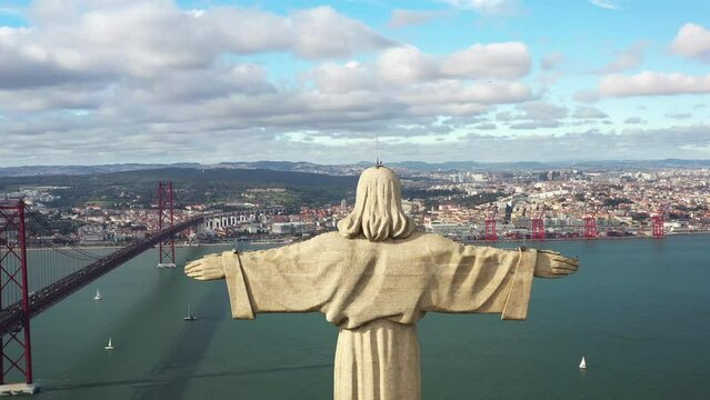 Christ the King, Almada, Portugal. Panorama Lisbon city with beautiful landmarks. Aerial view Tagus River and 25 de Abril Bridge in background blue sky