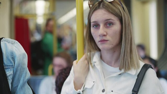 Mid adult business woman commuter is standing in bus and travelling in public transport