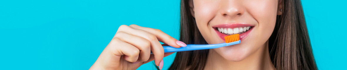 Happy girl brushing her teeth. The concept of a healthy lifestyle. Dental hygiene. Smiling young woman with healthy teeth holding a tooth brush. Young beautiful girl holding a toothbrush