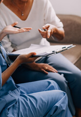 Doctor showing medical card to patient at table in clinic, closeup