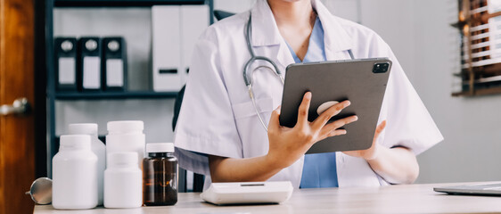 Medical doctor or physician consulting patient's health online using internet mobile digital tablet in clinic or hospital office for professional emergency healthcare assistance service concept