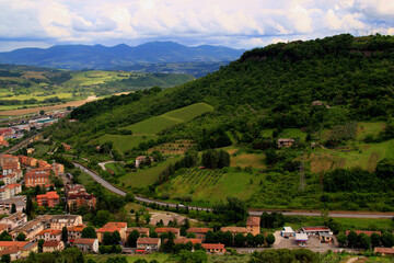 Fototapeta premium Landscape with green hills and mountains in the background with houses in the foreground in the city of Orvieto, Umbria region, Italy