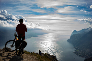 cyclist with mountain bike in the mountains overlooking Lake Garda in Italy