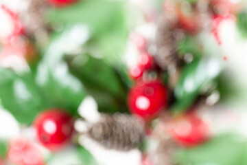 Blurred Christmas Background of Holly Branches and Pine Cones. Horizontal.