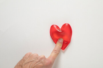 Concept of heart attack, finger pressing red heart shape Cardiology and medical care for infarct