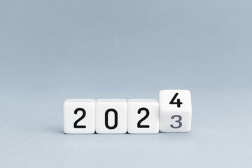 New Year concept. Change from 2023 to 2024 cube blocks isolated on blue background. Copy space