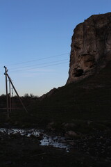 A rocky cliff with a cable line