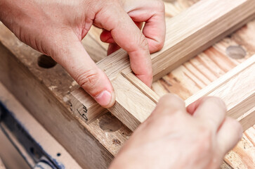 Craftsman hands glue wooden frame in workshop. Production of joinery