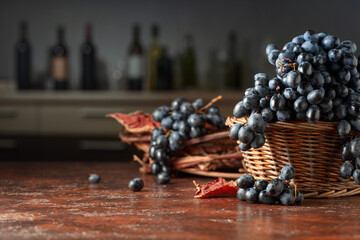 Blue grapes in old basket on a brown vintage table.