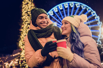 Photo of charming dreamy american guy lady wear windbreakers hugging enjoying xmas cacao together outside urban ferris wheel market park