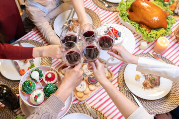 Asian Family cheering and drinking red wine celebrating Thanksgiving, Christmas or New Year party