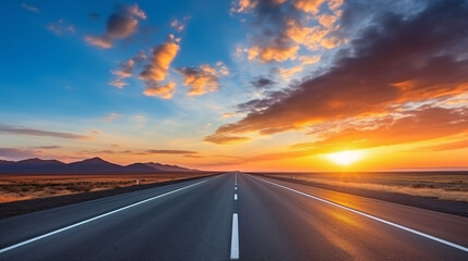 Empty asphalt road and city skyline at sunrise