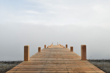 muelle de madera entre la niebla