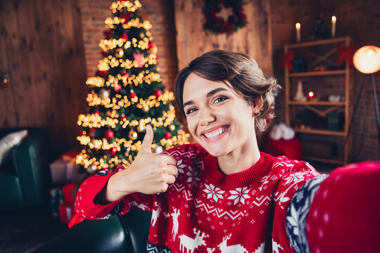 Selfie of toothy smiling girl young age vlog lifestyle buy gifts for miracle merry christmas thumb up isolated home interior background