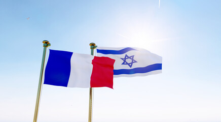 Israel and France flags waving against a blue sky background. 