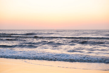 Sunrise over the sea. Pastel shades. Beautiful landscape. Sandy beach of the ocean. Sunset sky.