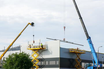 Sandwich panels wall assembly using telescopic boom crane and self propelled scissor lift platform © Zigmunds