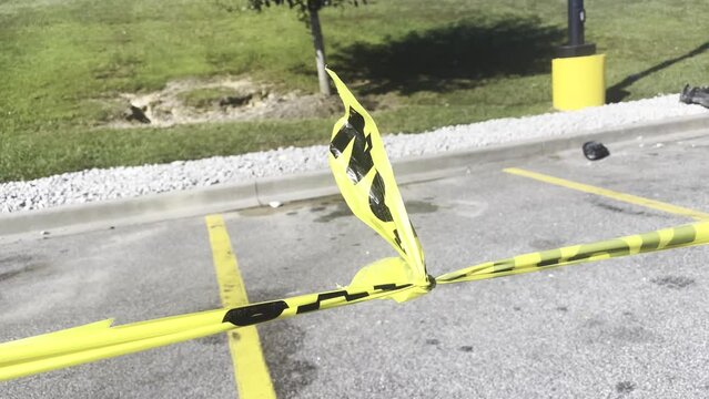 Yellow cation tape blowing in the wind in a parking lot