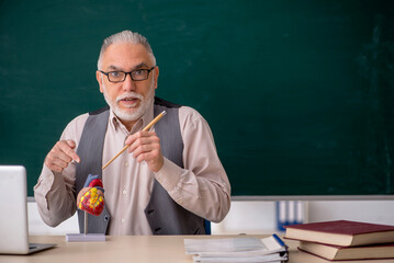 Old male teacher explaining human heart structure