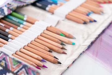 Obraz premium Painting supplies on a table. Pencils, white blank sheet of paper.