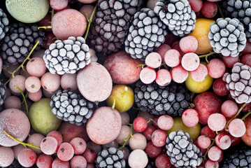Frozen berries fruits as background, top view. Fruits with hoarfrost. Mix of different frozen berries.