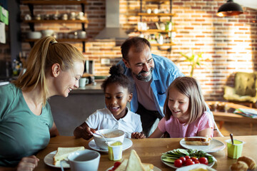 Stepfamily sharing a joyful meal together in the kitchen