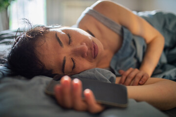 Woman resting peacefully with her smartphone beside her