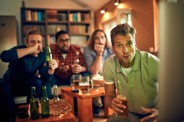 Elated friends celebrate a thrilling sports moment on TV