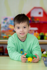 A child with Down syndrome plays in kindergarten