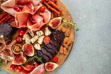 Appetizer food prosciutto ham cheese appetizers served with figs on a wooden board. place for text, top view