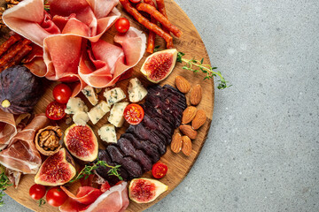Appetizer food prosciutto ham cheese appetizers served with figs on a wooden board. place for text,...
