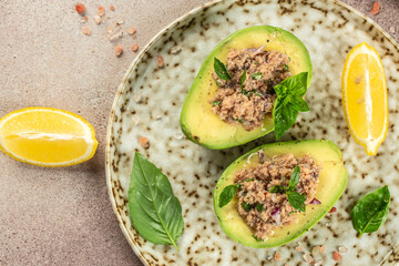 Salad of avocado and tuna on a light background top view. place for text
