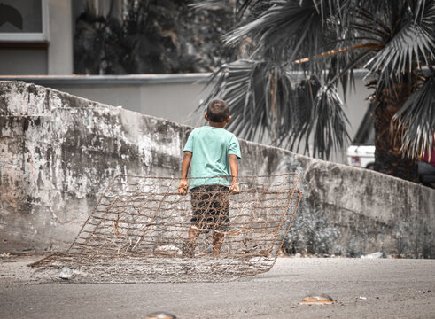 ni&ntilde;o arrastrando fierros y resortes de un colchon 
