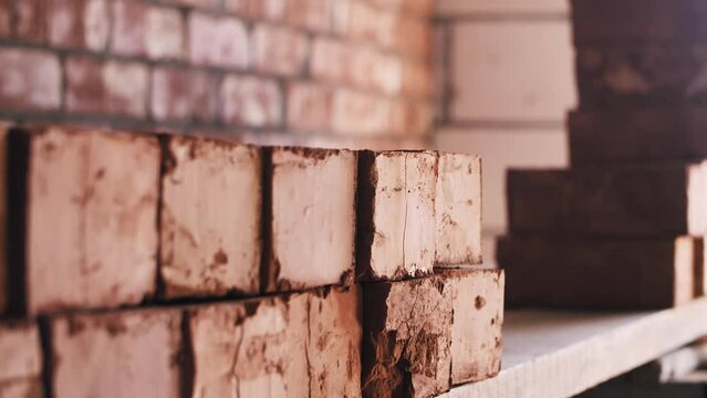Worker stacking red bricks at construction site