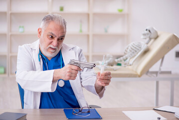 Old male doctor and skeleton patient in the clinic