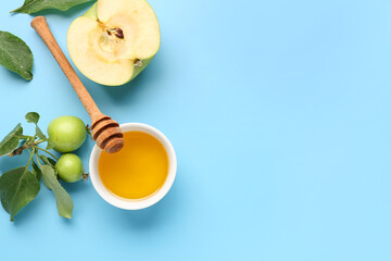 Bowl of honey and apples for Rosh Hashanah celebration (Jewish New Year) on blue background