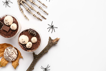 Plastic cups with delicious tiramisu, cookie, skeleton hand and spiders for Halloween celebration...
