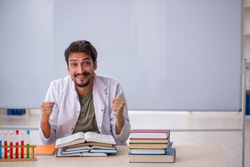 Young male chemist teacher in front of whiteboard